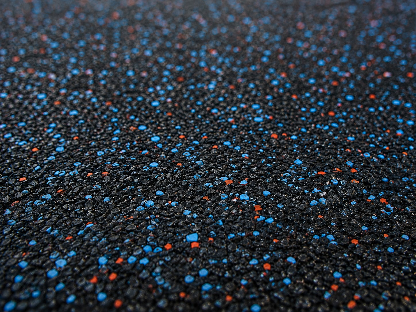 Crew hand-troweling poured-in-place rubber surfacing