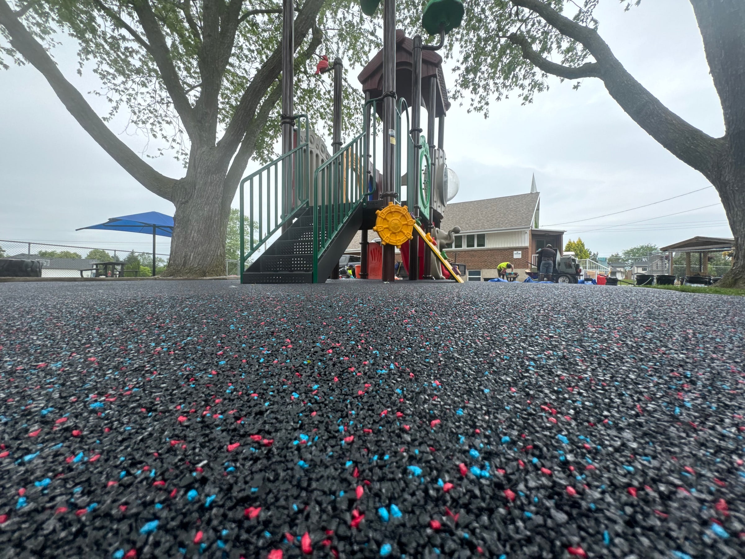 Blue rubber surfacing beneath a playground slide