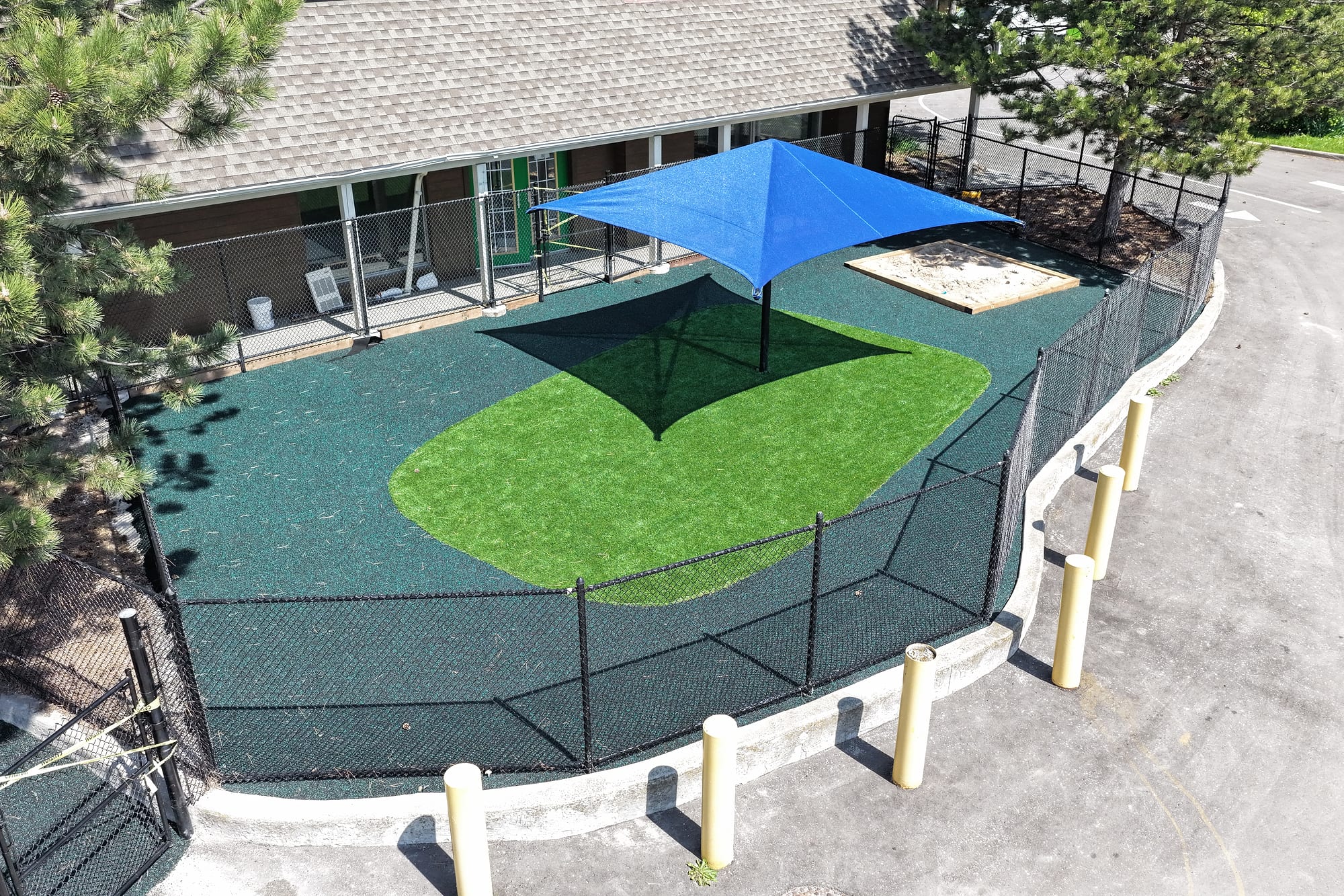 daycare yard blue shade sail artificial turf rubber surface