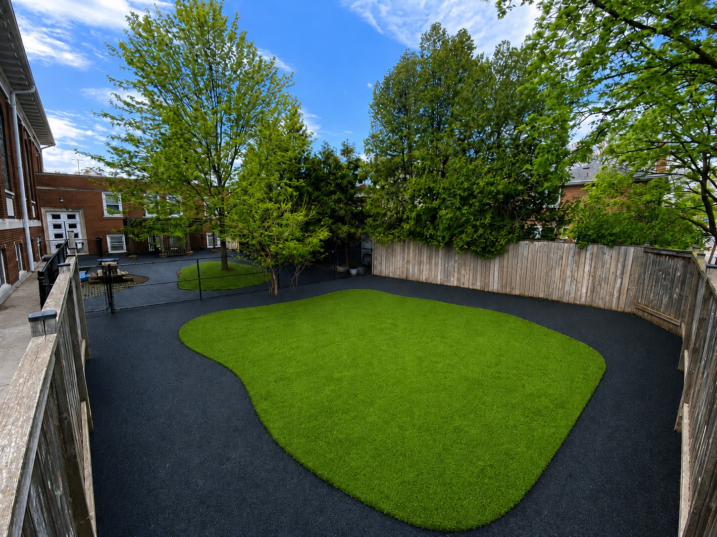 Wide daycare playground rubber surfacing with artificial turf