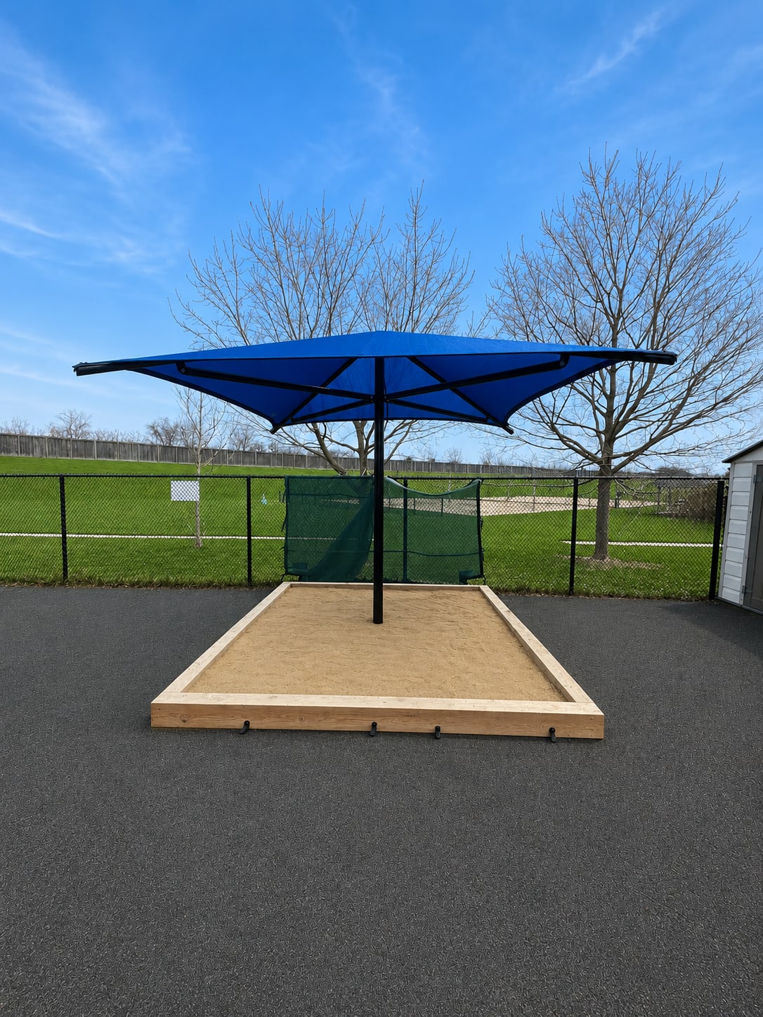 Blue sun shade over a daycare sandbox