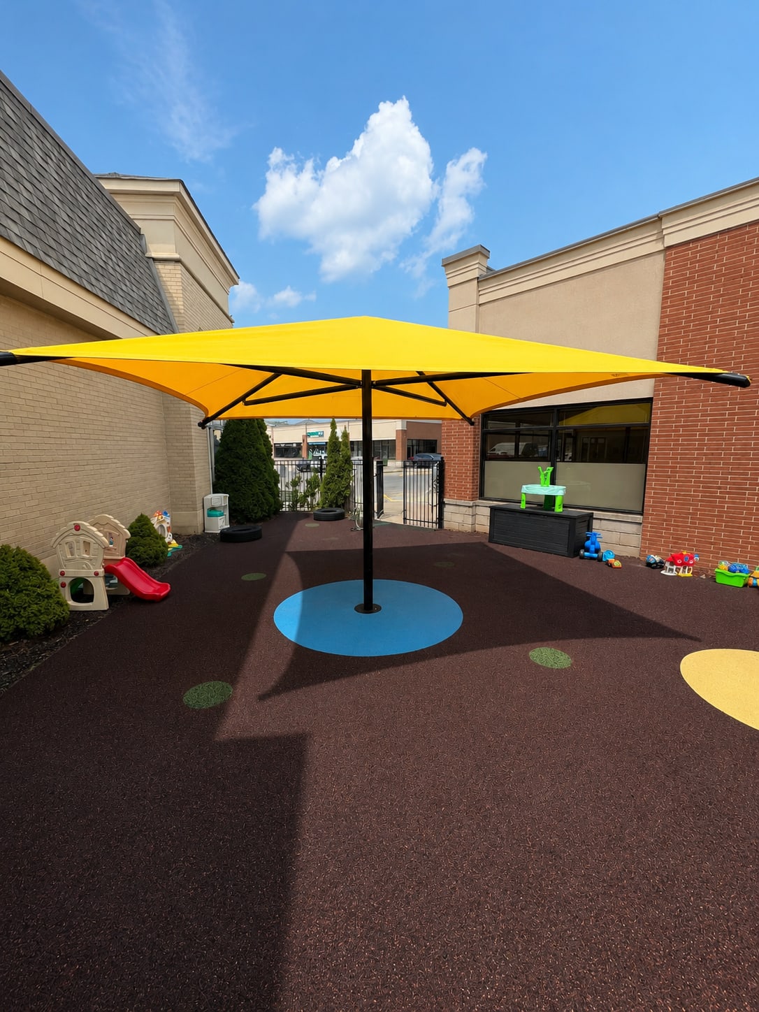 Yellow sun shade at a daycare by Rubberscape